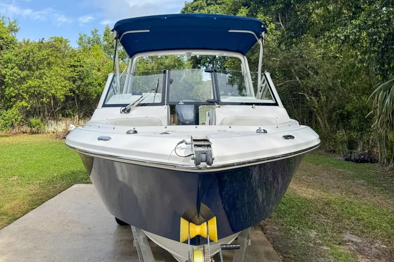 Slide: The Image of 2014 Everglades 230 Dual Console boat on trailer, surrounded by greenery. - 16