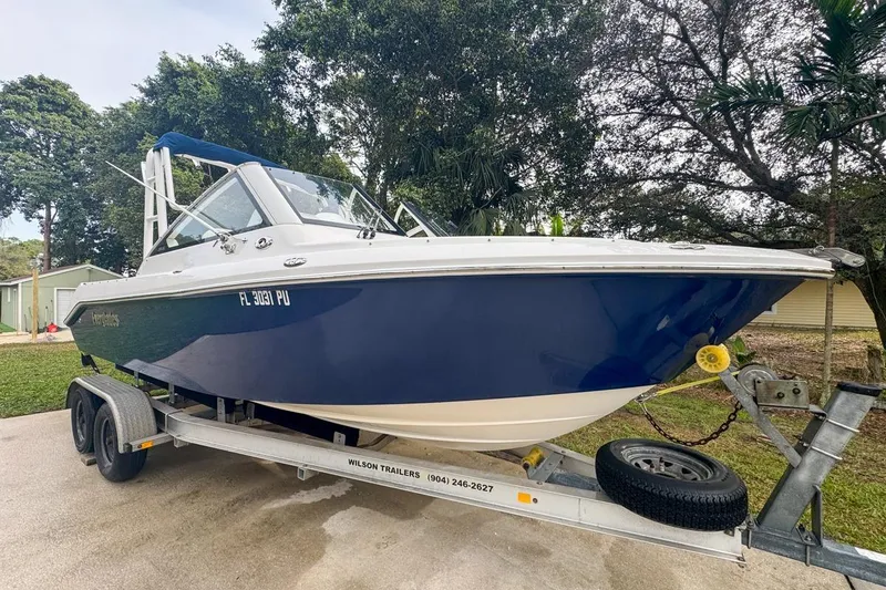 Slide: The Image of 2014 Everglades 230 Dual Console boat on trailer, parked outdoors. - 3
