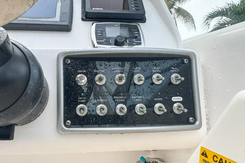 Slide: The Image of Control panel of a 2014 Everglades 230 Dual Console boat with various switches. - 43