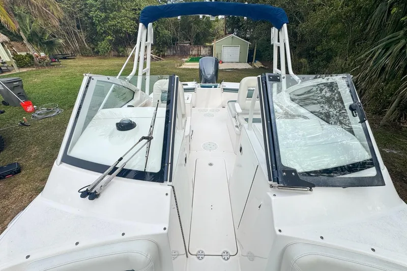 Slide: The Image of 2014 Everglades 230 Dual Console boat with open windshield, parked on grass. - 59