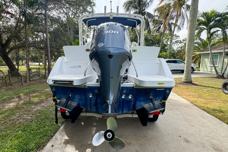 Slide: The Image of 2014 Everglades 230 Dual Console boat with powerful outboard motor, parked outdoors. - 6