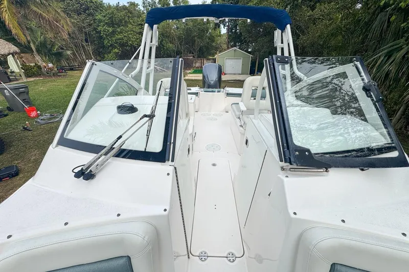 Slide: The Image of 2014 Everglades 230 Dual Console boat with open windshield, parked outdoors. - 60