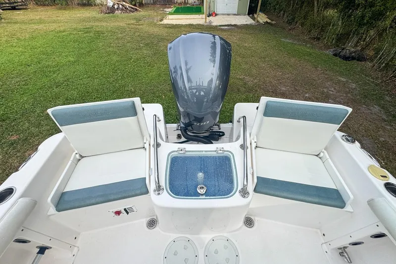 Slide: The Image of 2014 Everglades 230 Dual Console boat with seating and motor, parked on grass. - 76