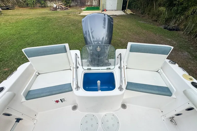 Slide: The Image of 2014 Everglades 230 Dual Console boat interior with seating and storage compartments. - 77