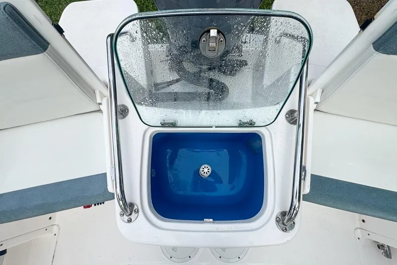 Slide: The Image of 2014 Everglades 230 Dual Console boat with open livewell and wet glass cover. - 78