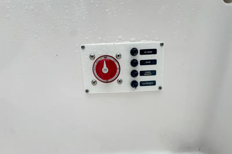 Slide: The Image of Control panel on a 2014 Everglades 230 Dual Console boat, featuring switches and a red dial. - 80