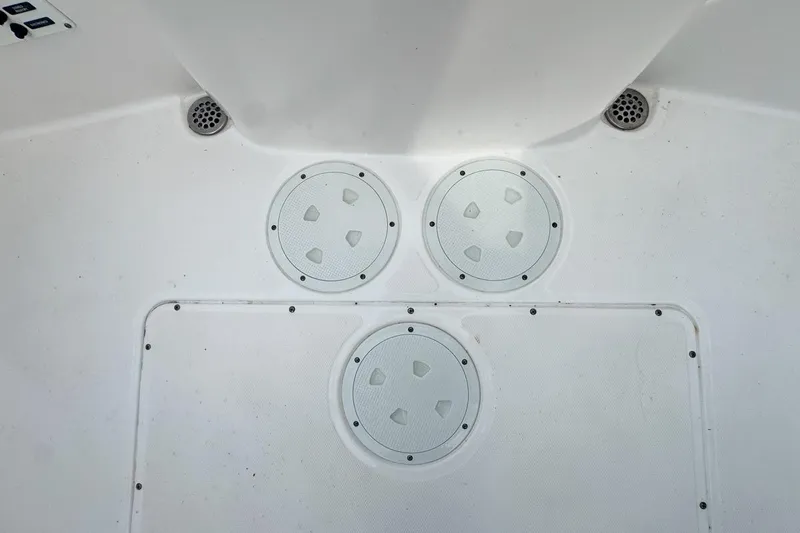 Slide: The Image of 2014 Everglades 230 Dual Console boat deck with circular hatches and drains. - 81