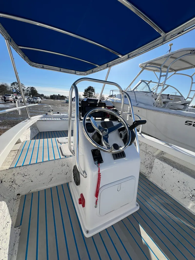 Slide: The Image of Interior view of a 2021 C-Hawk 16 Tiller boat with blue canopy. - 14
