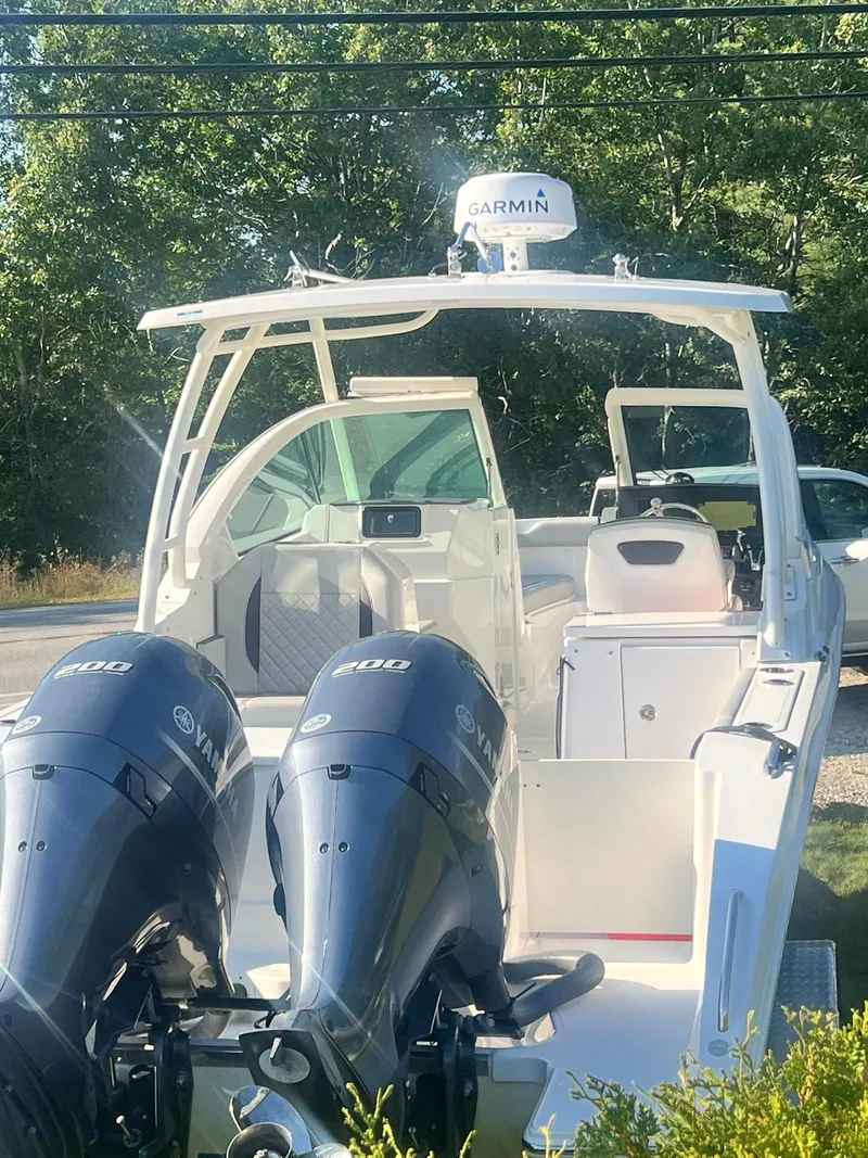 Slide: The Image of 2022 Pursuit DC 266 Dual Console boat with twin Yamaha engines, parked outdoors. - 16