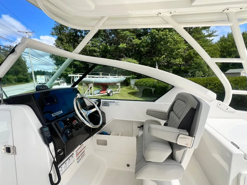 Slide: The Image of 2022 Pursuit DC 266 Dual Console boat interior with steering wheel and seating. - 19