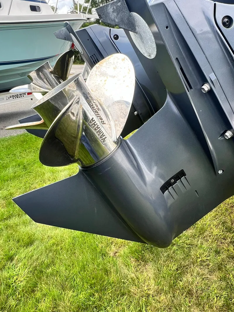 Slide: The Image of Close-up of a 2022 Pursuit DC 266 Dual Console boat propeller on grass. - 21