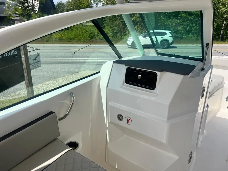 Slide: The Image of 2022 Pursuit DC 266 Dual Console boat interior with seating and dashboard view. - 22