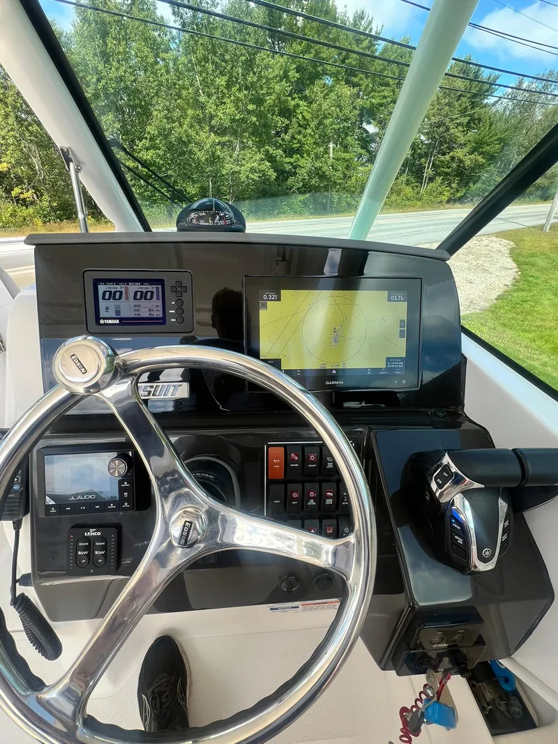 Slide: The Image of 2022 Pursuit DC 266 Dual Console boat dashboard with navigation screens and steering wheel. - 30
