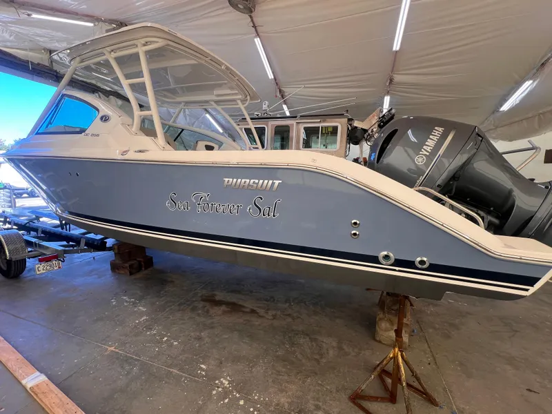 Slide: The Image of 2022 Pursuit DC 266 Dual Console boat in storage, featuring Yamaha outboard motor. - 35