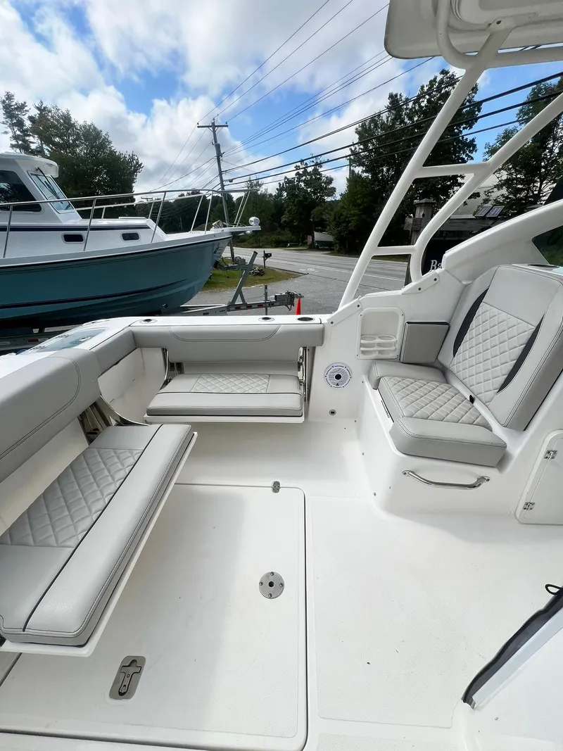 Slide: The Image of 2022 Pursuit DC 266 Dual Console boat interior with cushioned seating and open deck. - 9