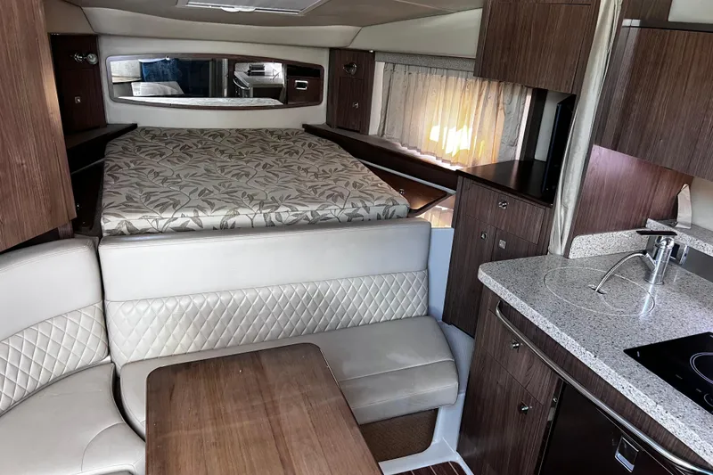 Slide: The Image of Luxurious interior of 2011 Chaparral 310 Signature boat with bed, seating, and kitchenette. - 22