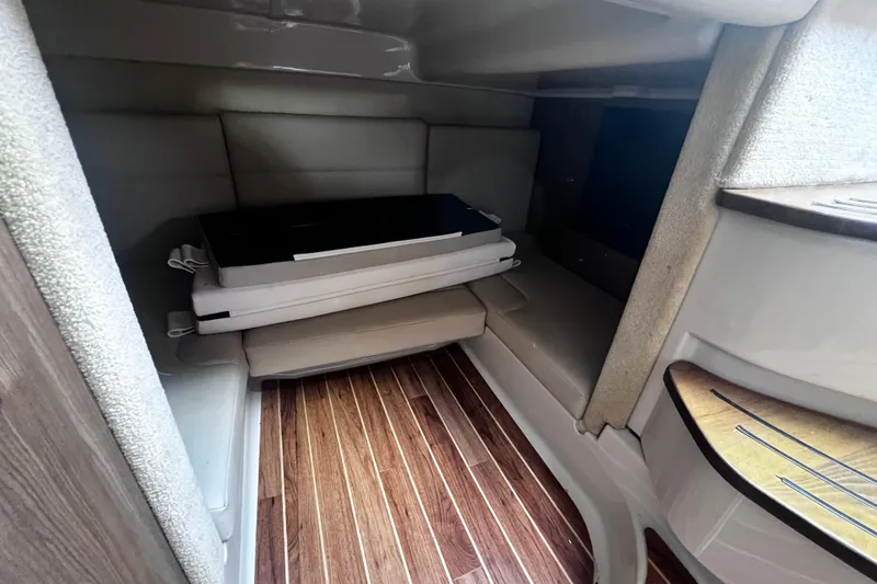 Slide: The Image of 2011 Chaparral 310 Signature cabin interior with wood flooring and cushioned seating. - 24