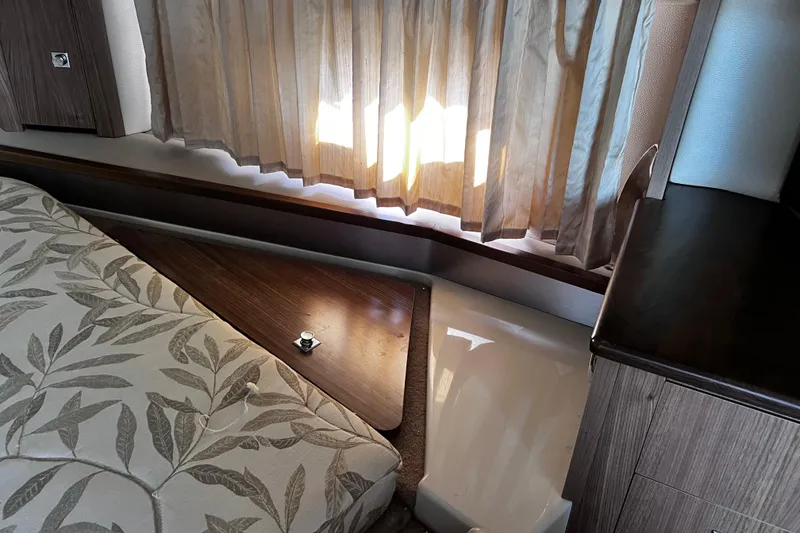 Slide: The Image of Interior of 2011 Chaparral 310 Signature with patterned bedding and wooden accents. - 29