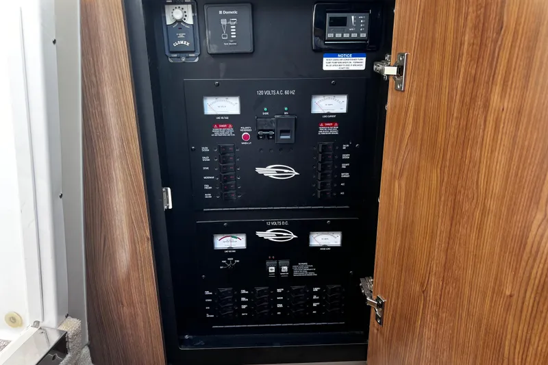 Slide: The Image of Electrical panel inside 2011 Chaparral 310 Signature boat, featuring voltage and load meters. - 32