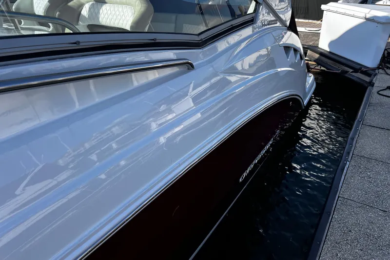 Slide: The Image of 2011 Chaparral 310 Signature boat docked, showcasing sleek design and white exterior. - 36