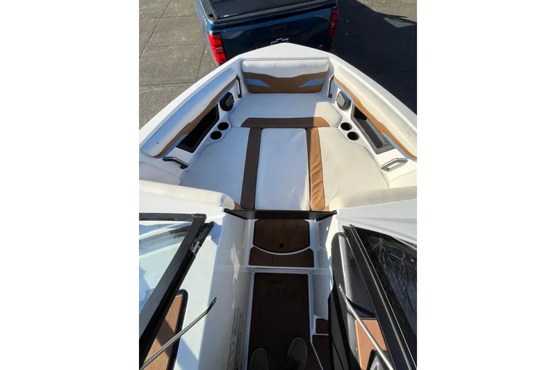 Slide: The Image of 2024 Axis T220 boat interior with white and brown seating, cup holders, and sleek design. - 11