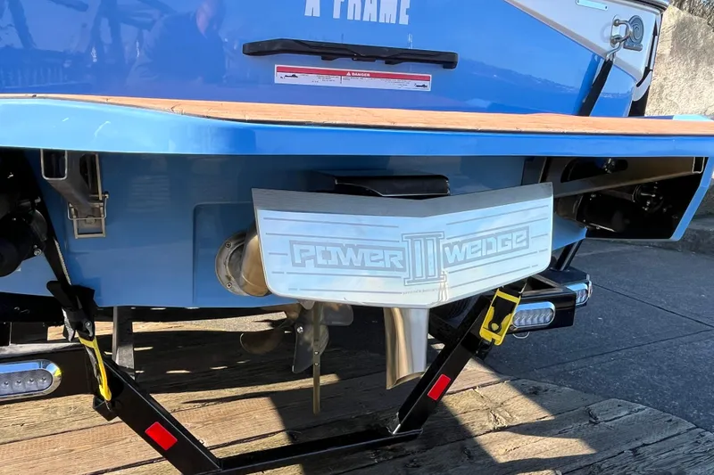 Slide: The Image of 2024 Axis T220 boat with Power Wedge III, blue exterior, docked on wooden platform. - 15