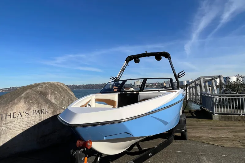 Slide: The Image of 2024 Axis T220 boat at Thea's Park dock under clear blue sky. - 3