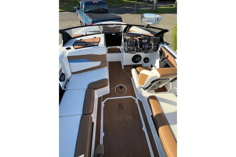 Slide: The Image of 2024 Axis T220 boat interior with brown and white seating, modern dashboard, and spacious layout. - 9