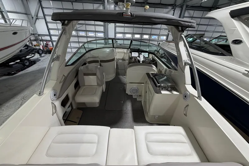 Slide: The Image of 2012 Sea Ray 300 SLX boat interior with seating and helm in a storage facility. - 15