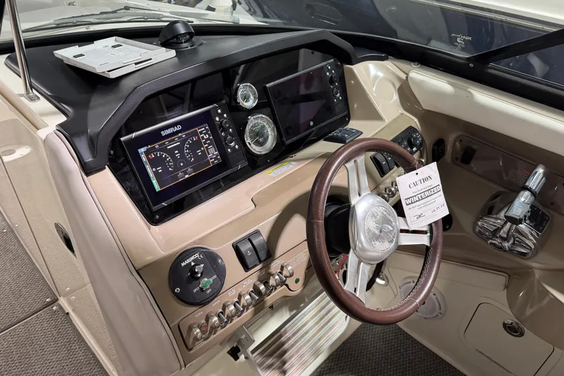 Slide: The Image of 2012 Sea Ray 300 SLX boat dashboard with steering wheel and navigation controls. - 23