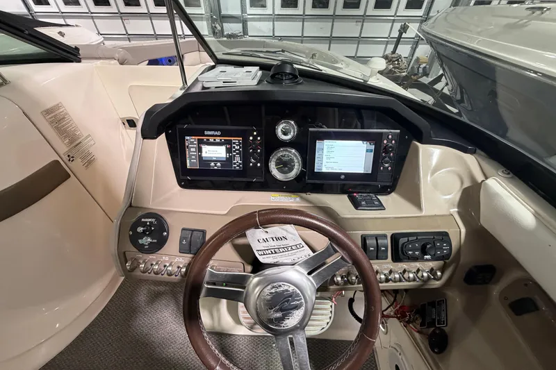 Slide: The Image of 2012 Sea Ray 300 SLX dashboard with steering wheel, navigation screens, and control panel. - 29