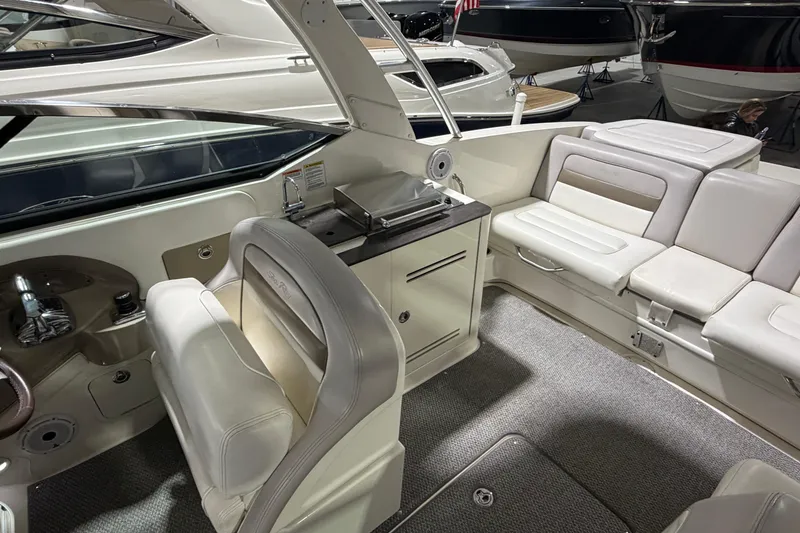 Slide: The Image of 2012 Sea Ray 300 SLX boat interior with white seating and helm station. - 32