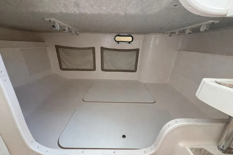 Slide: The Image of 2003 Grady-White Marlin 300 cabin interior with storage compartments and netted windows. - 10