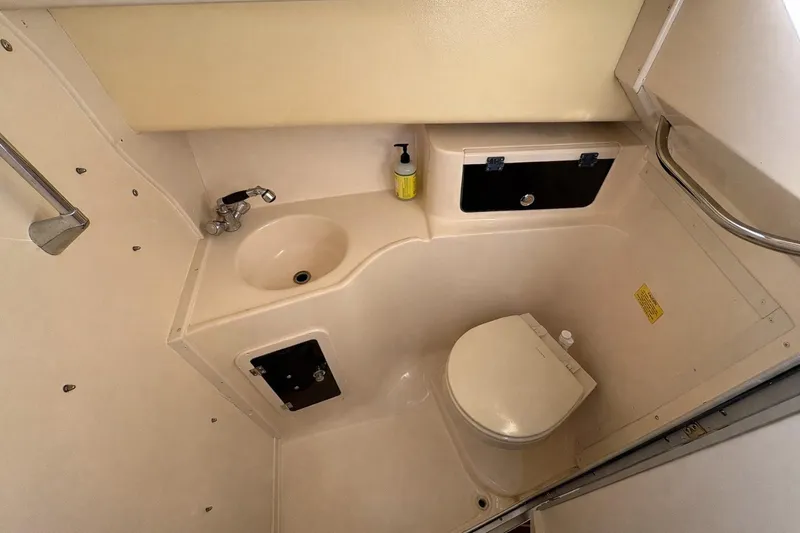 Slide: The Image of 2003 Grady-White Marlin 300 boat bathroom with sink, toilet, and storage compartments. - 12
