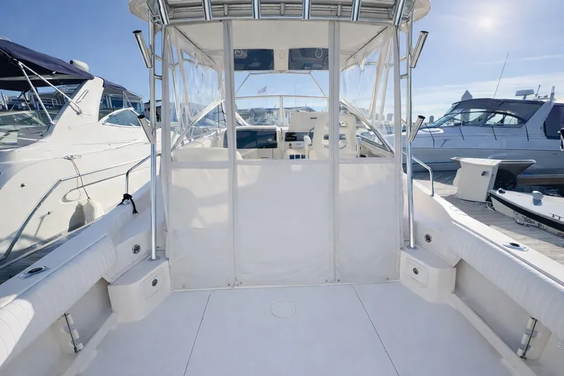 Slide: The Image of 2003 Grady-White Marlin 300 boat interior, featuring spacious deck and seating at marina. - 4
