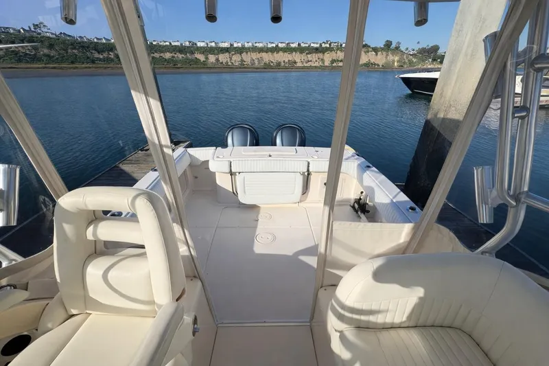 Slide: The Image of 2003 Grady-White Marlin 300 boat interior with seating, docked by a scenic shoreline. - 5