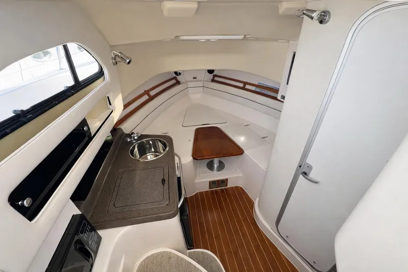 Slide: The Image of 2003 Grady-White Marlin 300 cabin interior with kitchenette and seating area. - 7