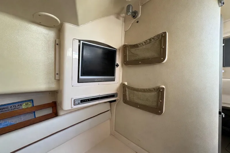 Slide: The Image of 2003 Grady-White Marlin 300 cabin interior with TV and storage nets. - 9