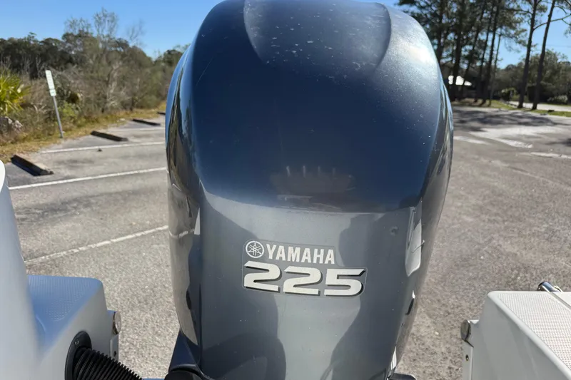 Slide: The Image of Yamaha 225 outboard motor on 2005 Sailfish 218 CC boat, parked outdoors. - 13