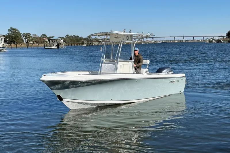 Slide: The Image of 2005 Sailfish 218 CC boat on calm water with a person at the helm. - 2