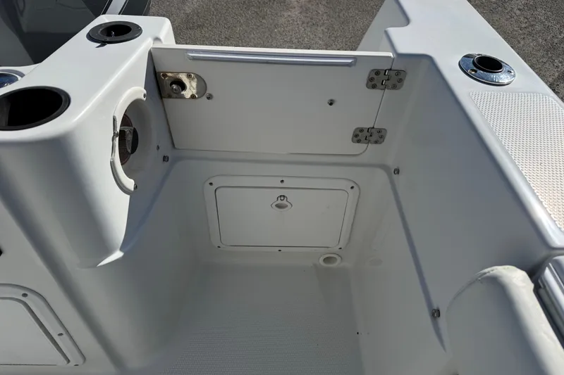 Slide: The Image of 2005 Sailfish 218 CC boat interior with storage compartment and cup holders. - 27