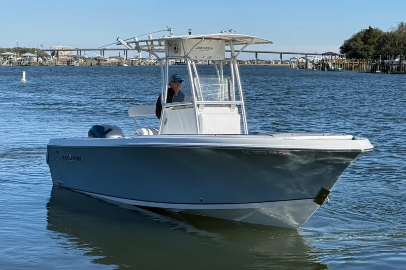 Slide: The Image of 2005 Sailfish 218 CC boat cruising on a calm river with a bridge in the background. - 4