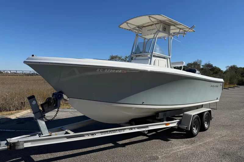 Slide: The Image of 2005 Sailfish 218 CC boat on trailer, parked outdoors under clear blue sky. - 9