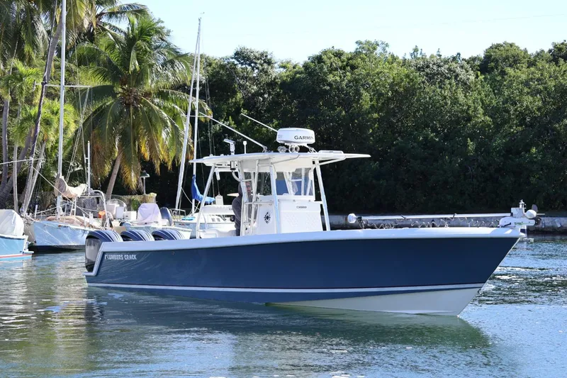 The Image of 2007 Contender 33 Tournament boat on water, surrounded by lush greenery and other boats. - 0