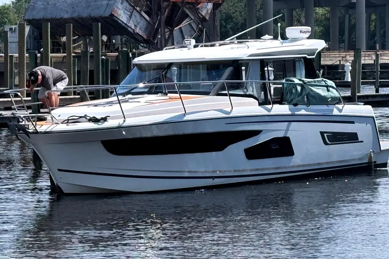 Slide: The Image of 2021 Jeanneau NC Weekender 1095 boat docked at marina with person on deck. - 6