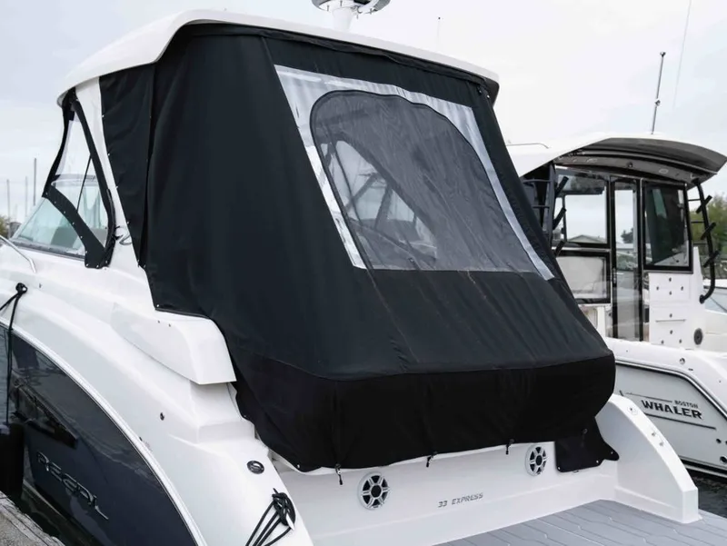 Slide: The Image of 2026 Regal 33 Express with black cover docked at marina. - 10