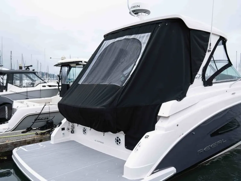 Slide: The Image of 2026 Regal 33 Express yacht docked with black cover. - 11