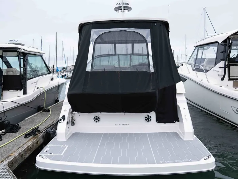 Slide: The Image of 2026 Regal 33 Express docked, rear view with black canopy. - 9