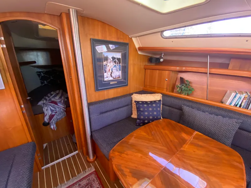 Slide: The Image of Interior of a 2006 Hunter 38 yacht with wooden table and seating area. - 28