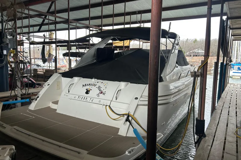 Slide: The Image of 1998 Cruisers Yachts 4270 Express docked in a marina, covered and secured. - 1
